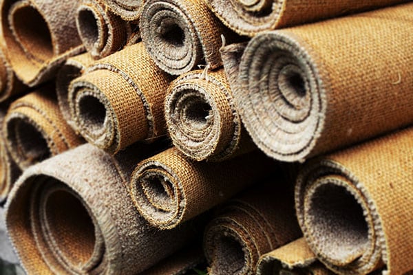Rolled up old carpets ready to be recycled