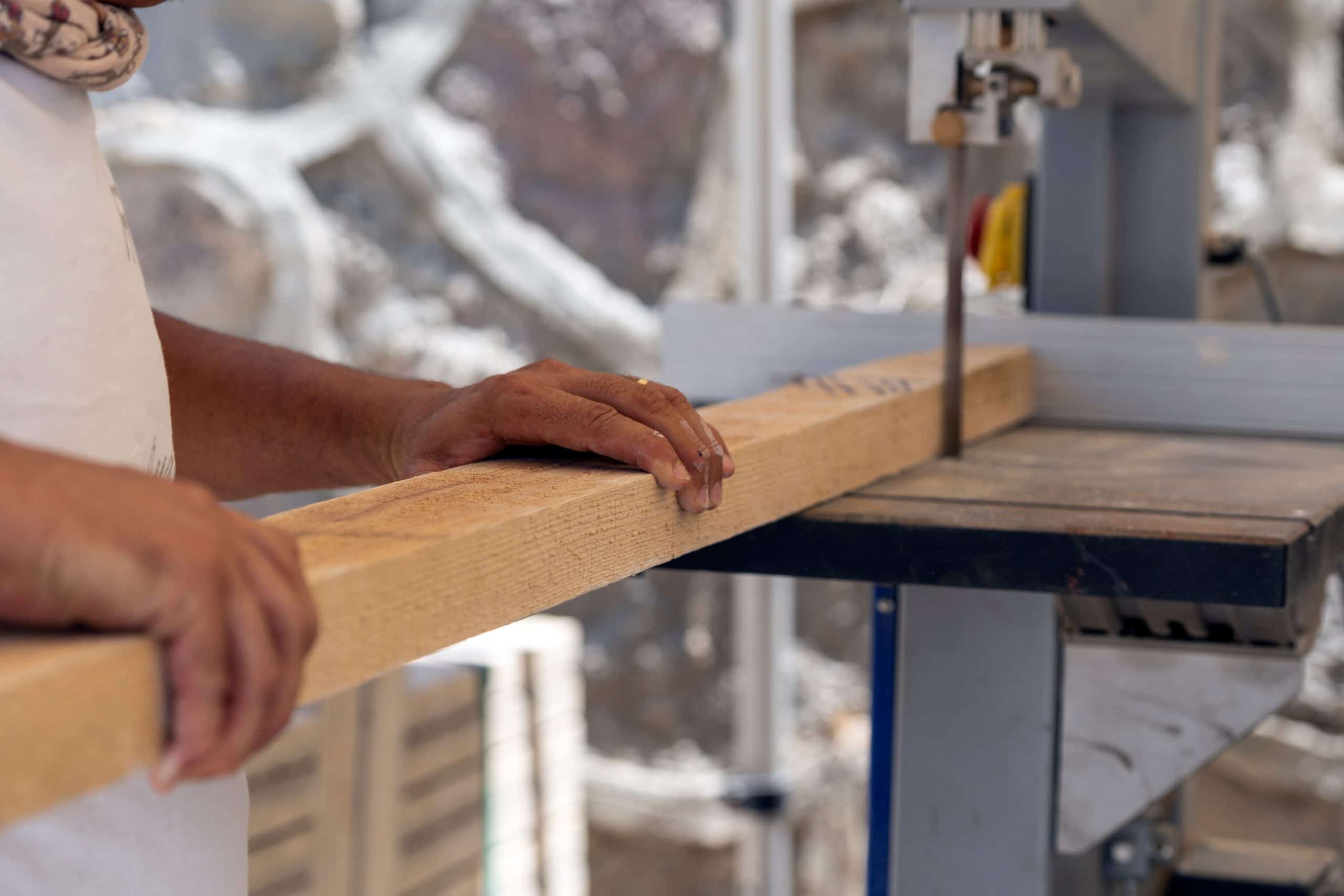 Bandsaw operator cutting through a piece of wood