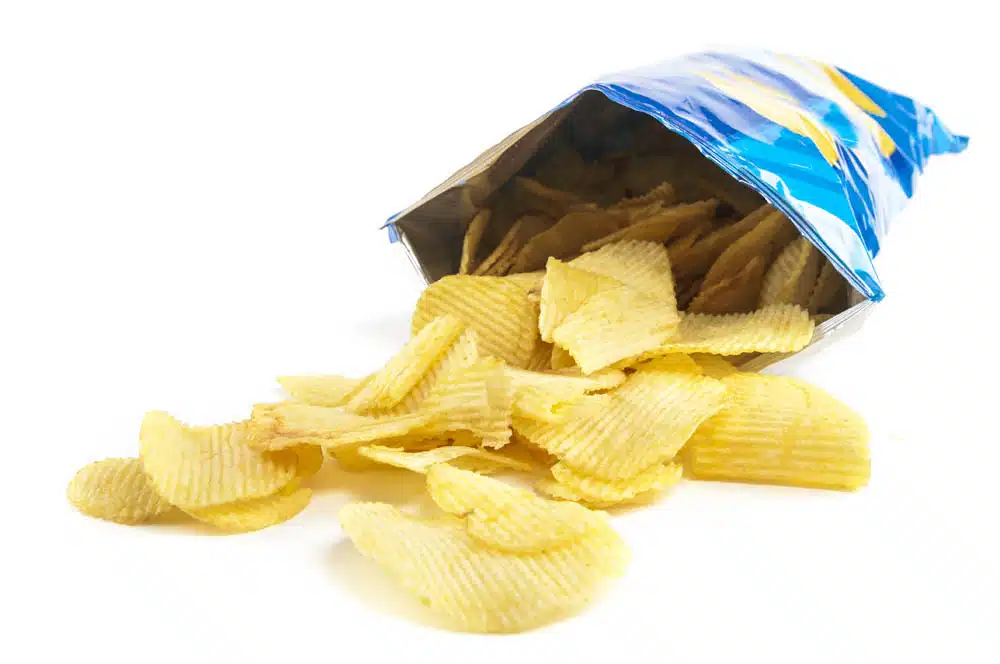 Potato chips spilling from a plastic chip bag