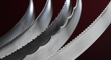 Various Simmons' foam cutting blades curve and catch the light against a dark background.