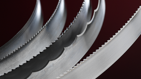 Various Simmons' foam cutting blades curve and catch the light against a dark background.