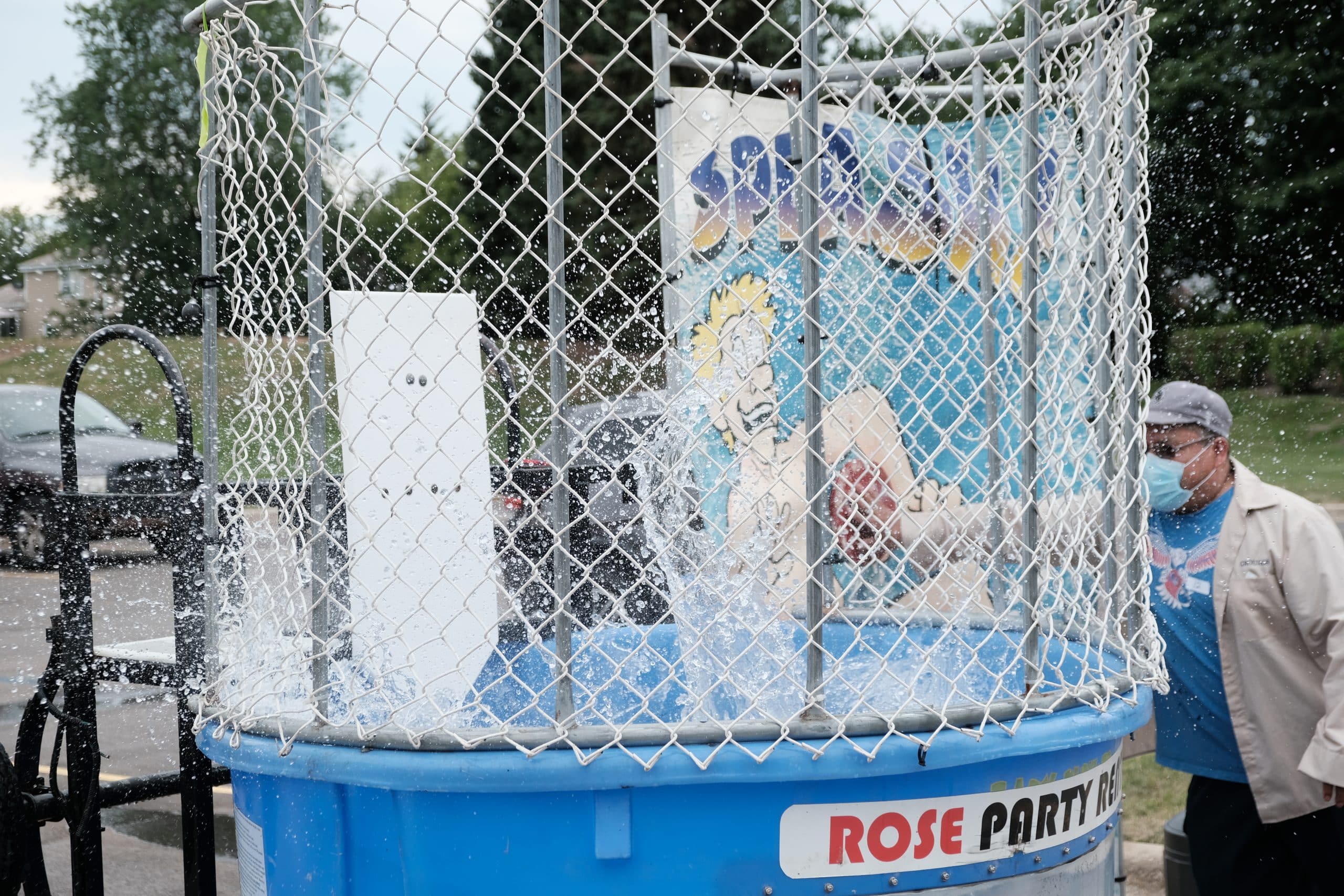Water splashes into the air after a Simmons employee dunks Production Manager Enver Baftijari.