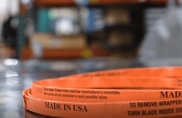 A Simmons Butcher bandsaw blade wrapped in orange paper on a stainless steel table.