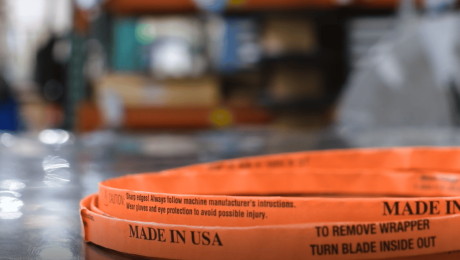 A Simmons Butcher bandsaw blade wrapped in orange paper on a stainless steel table.