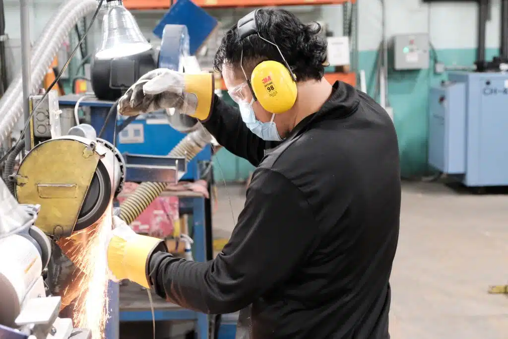 Simmons employee grinds the weld of a bandsaw blade.